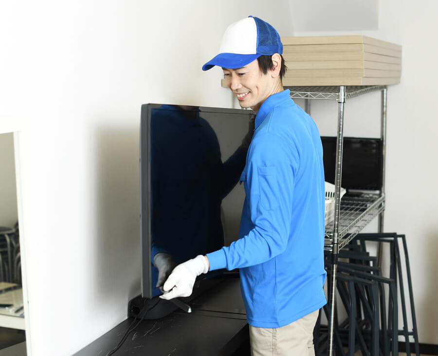 家電を慎重に運ぶ配送スタッフ