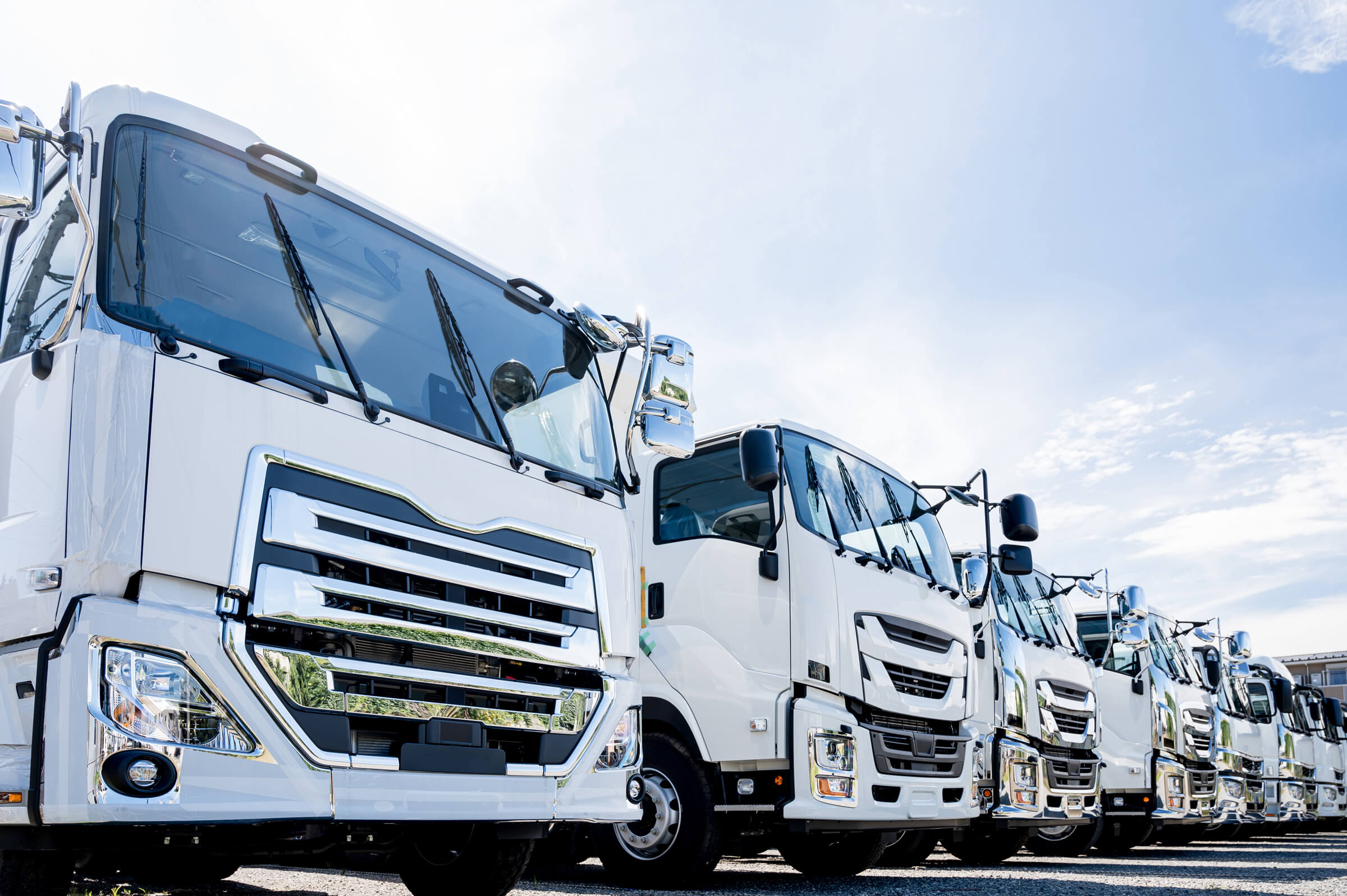 最新の物流倉庫内で、Astariskのロゴ入り制服を着た配送スタッフが、家電製品を丁寧に最終確認し、笑顔で顧客企業担当者と打ち合わせている様子。信頼感とプロフェッショナリズムが伝わる。